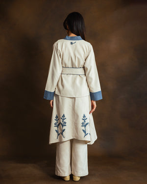Back view of cream wool-blend kimono jacket with blue gabardine trim and matching trousers.