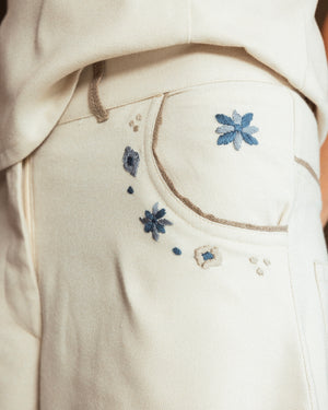 Close-up of hand-embroidered mosaic detailing and raffia trim on the pockets of the Mosaico Bubble Pants.