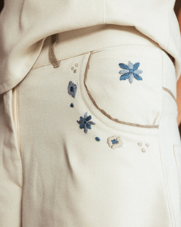 Close-up of hand-embroidered mosaic detailing and raffia trim on the pockets of the Mosaico Bubble Pants.