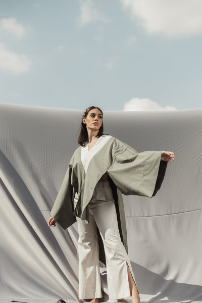 A butterfly sleeve Poplin Cotton blouse in Khaki and Beige detailed by asymmetrical cuts and a graceful cape.