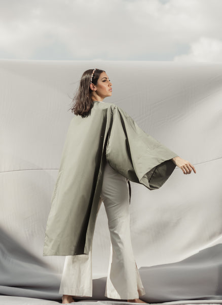 A butterfly sleeve Poplin Cotton blouse in Khaki and Beige detailed by asymmetrical cuts and a graceful cape.